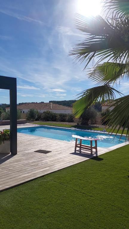 une table de pique-nique sur une terrasse à côté d'une piscine dans l'établissement Villa Saint Laï 4 chambres 8 personnes, à Lorgues