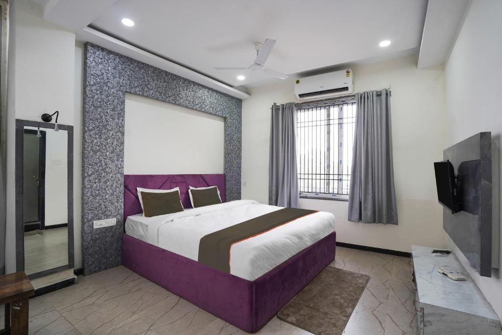 ein Schlafzimmer mit einem großen Bett und einem TV in der Unterkunft Hotel City Pride in Raipur