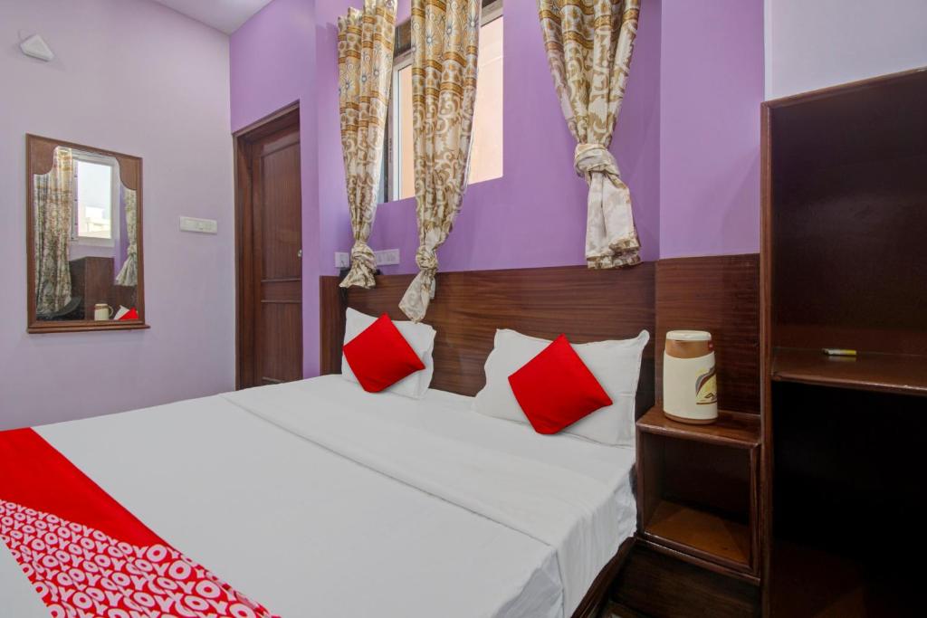 Schlafzimmer mit einem Bett mit roten und weißen Kissen in der Unterkunft Hotel Rameshwaram in Jaipur