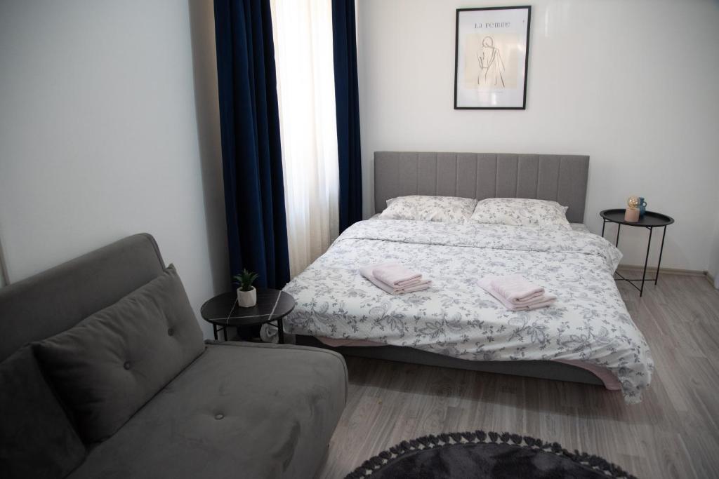 a bedroom with a bed and a couch at Nano Apartment in Prizren
