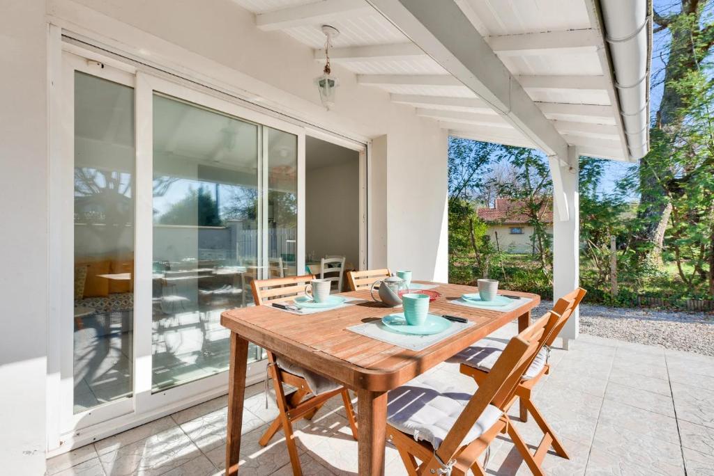une salle à manger avec une table et des chaises en bois dans l'établissement Maisonnette à deux pas de la plage, à Andernos-les-Bains