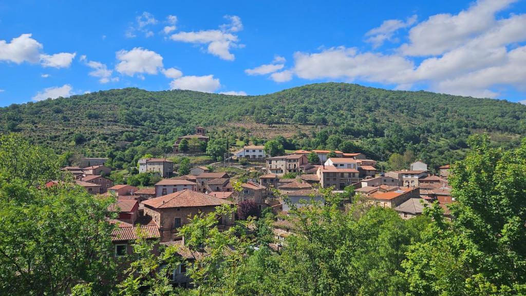 ein Dorf auf einem Hügel mit einem Berg im Hintergrund in der Unterkunft El Najerilla. Casa de pueblo in Villavelayo