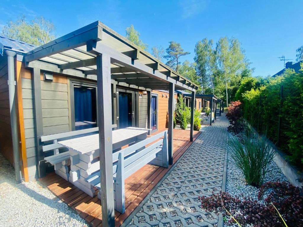 una piccola casa con un portico su un vialetto di Bungalow in Dziwnów near Baltic Sea Promenade a Dziwnów