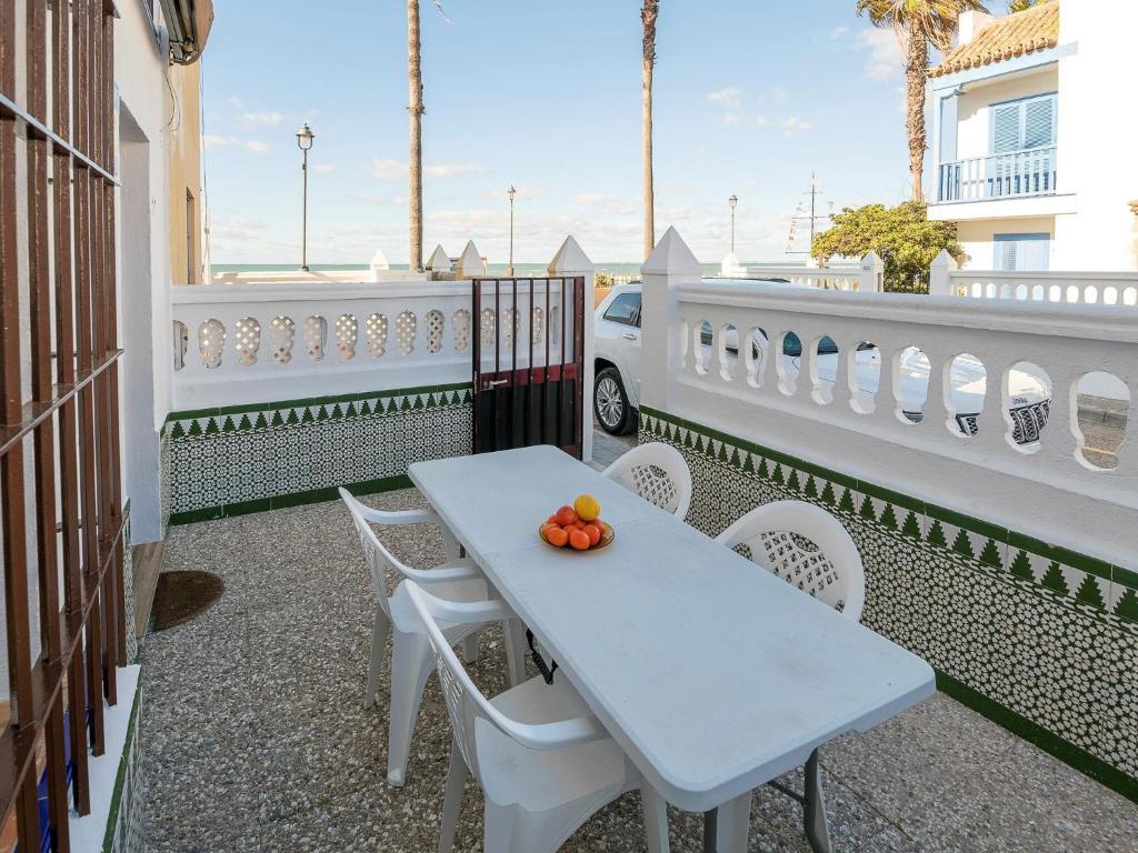 een witte tafel en stoelen op een balkon bij Traditional holiday home with terrace in Chipiona