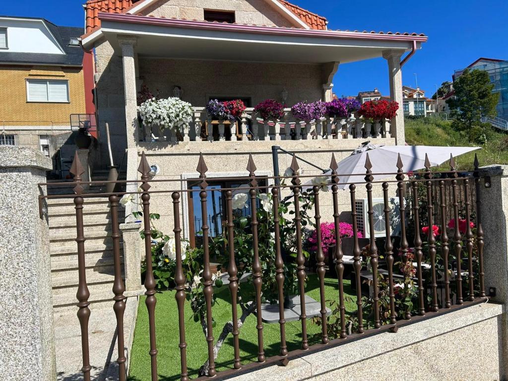une clôture en fer forgé avec des fleurs sur un balcon dans l'établissement masandia, à Moaña