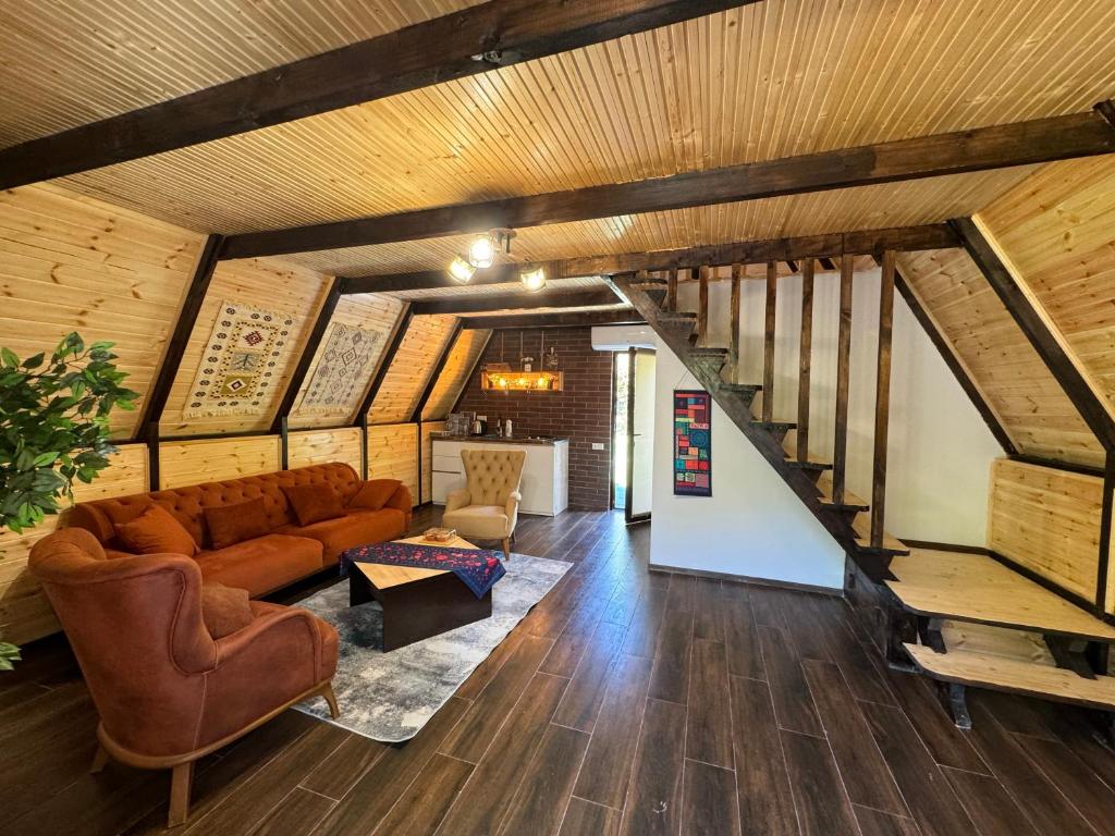 ein Wohnzimmer mit einem Sofa und einer Treppe in der Unterkunft cottage machakhela in Batumi