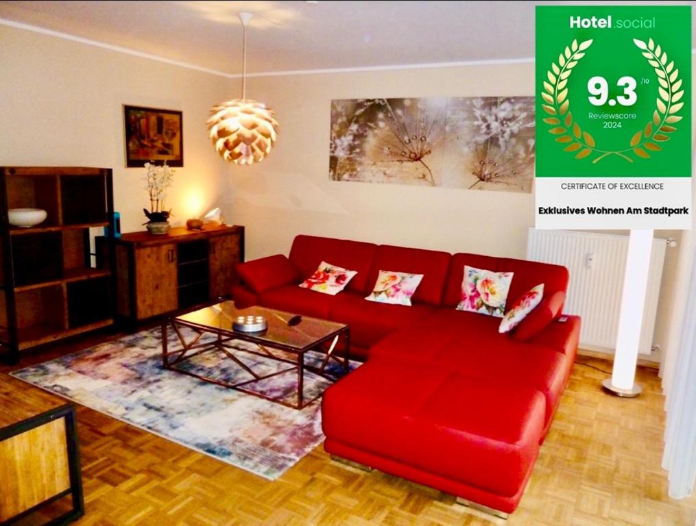 ein Wohnzimmer mit einem roten Sofa und einem Tisch in der Unterkunft Exklusives Wohnen am Stadtpark in Bad Driburg