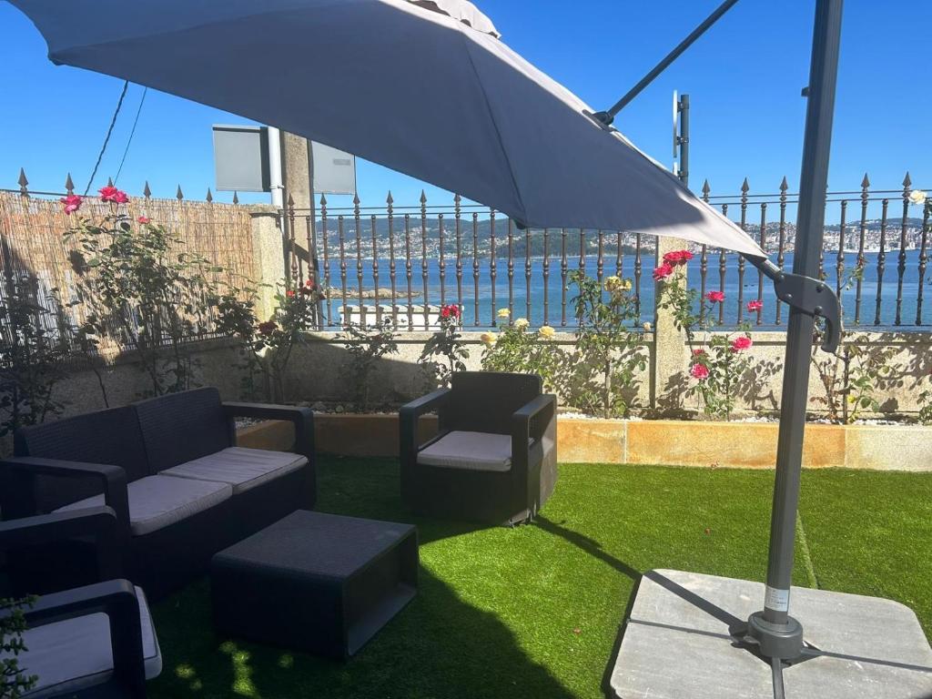 a patio with two chairs and an umbrella at masandia in Moaña