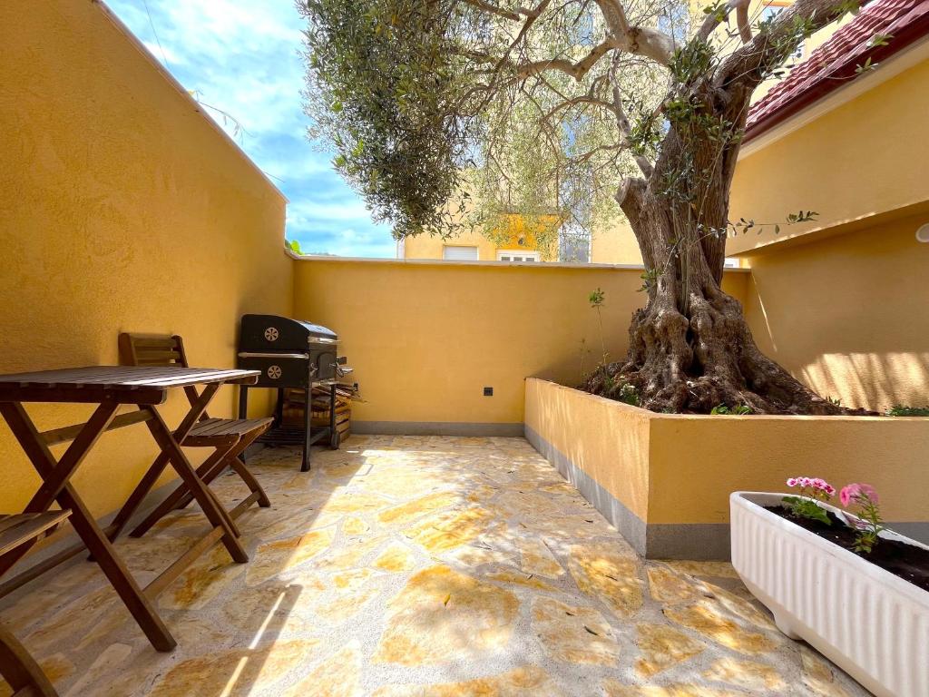 una habitación con una mesa y un árbol en la esquina en Olive Tree en Stari Grad