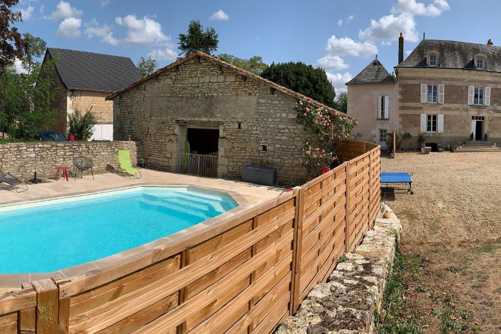 a fence around a swimming pool in front of a building at Les Gîtes du Chaix in Dissay