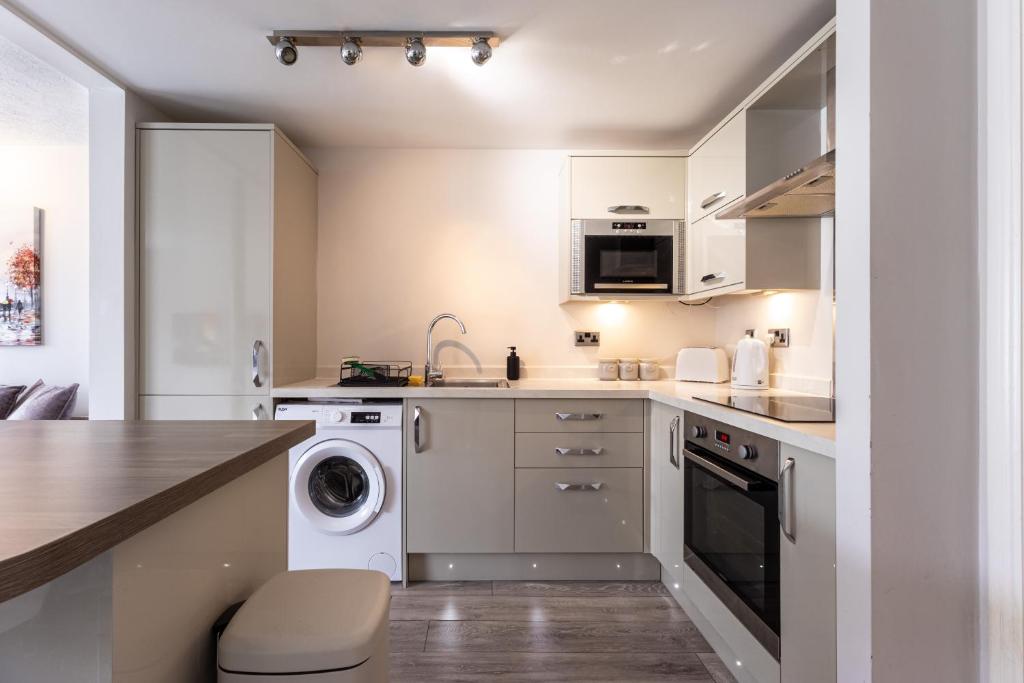 a kitchen with a washing machine and a washer and dryer at Modern 2 Bed Apartment Near Gatwick in Crawley
