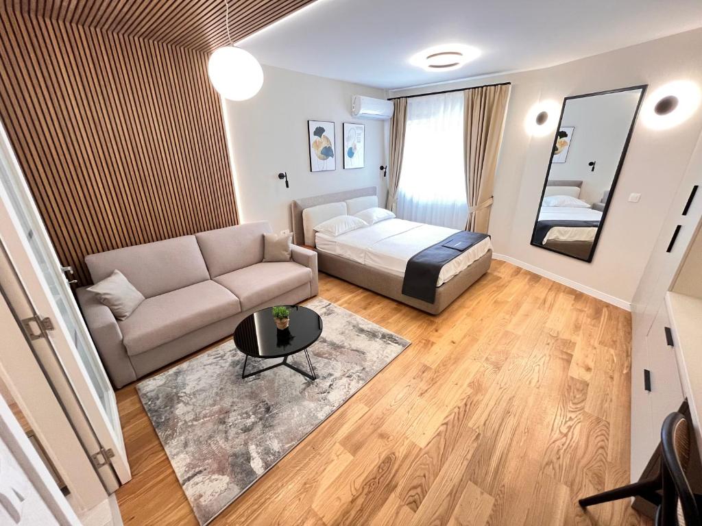 a living room with a couch and a bed at APART 28- Luxury suites in Podgorica