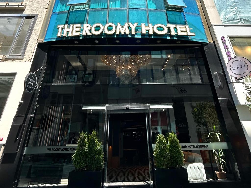 un hotel con un cartel en la parte delantera de un edificio en The Roomy Hotel Nişantaşı en Estambul