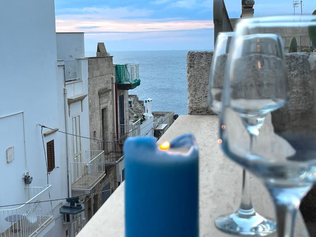 d'un verre de vin assis sur une corniche avec vue sur l'océan dans l'établissement Casa Maya, Vista Mare e Relax, à Polignano a Mare