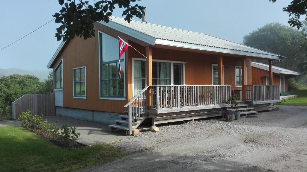 a small house with a flag on the porch at Storeval feriehus Nærøysund in Kolvereid