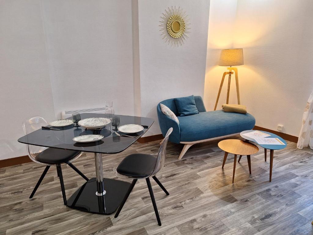 un salon avec une table et un canapé bleu dans l'établissement Bords de Loire hypercentre Orléans 2 personnes, à Orléans
