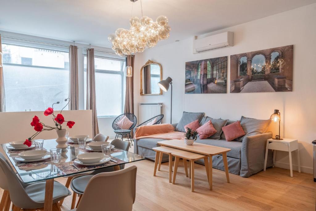 uma sala de estar com um sofá e uma mesa em Appartement spacieux et rénové em Paris
