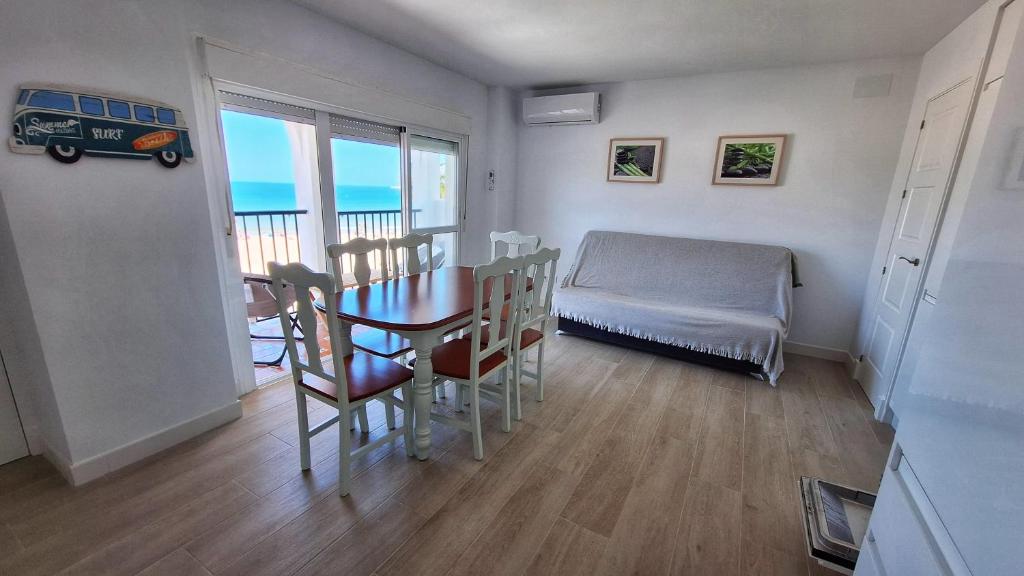 Zimmer mit einem Tisch, Stühlen und einem Bett in der Unterkunft TU DENSCANSO EN VALDELAGRANA FRENTE AL MAR in El Puerto de Santa María