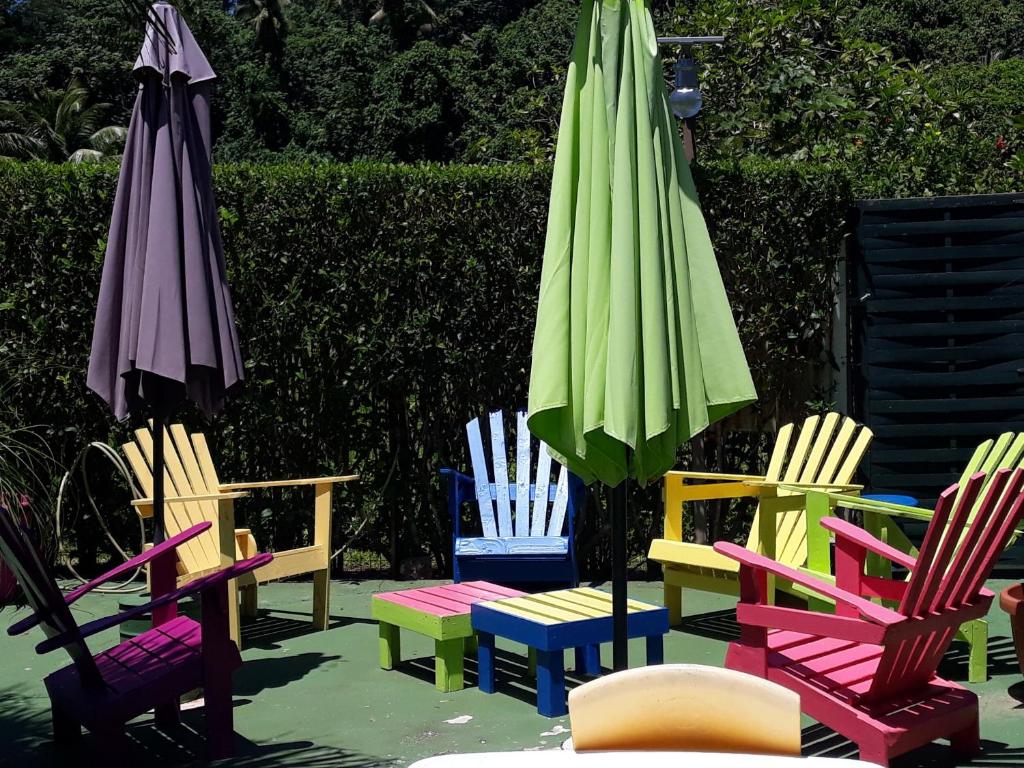 grupa kolorowych krzeseł i parasola w obiekcie Teavapiti Lodge w Uturoa