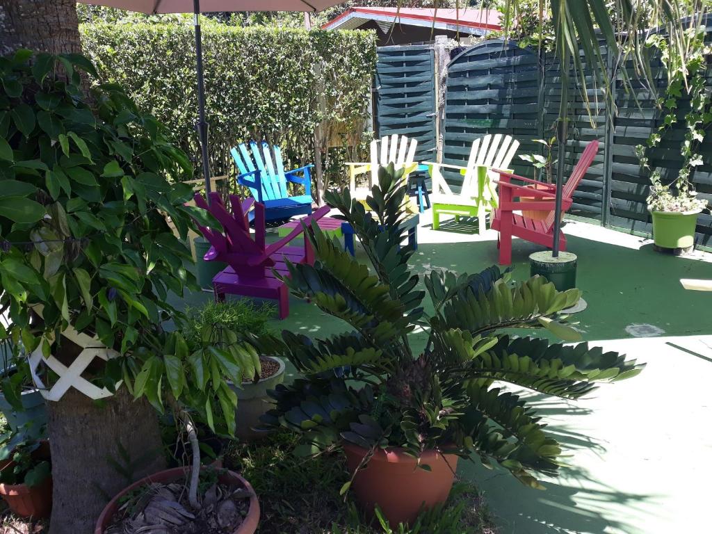 a group of colorful chairs and plants in a garden at Teavapiti Lodge in Uturoa