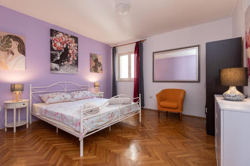 ein Schlafzimmer mit einem Bett, einem Tisch und einem Stuhl in der Unterkunft Spacious City Center apartment - 4 pax in Dubrovnik