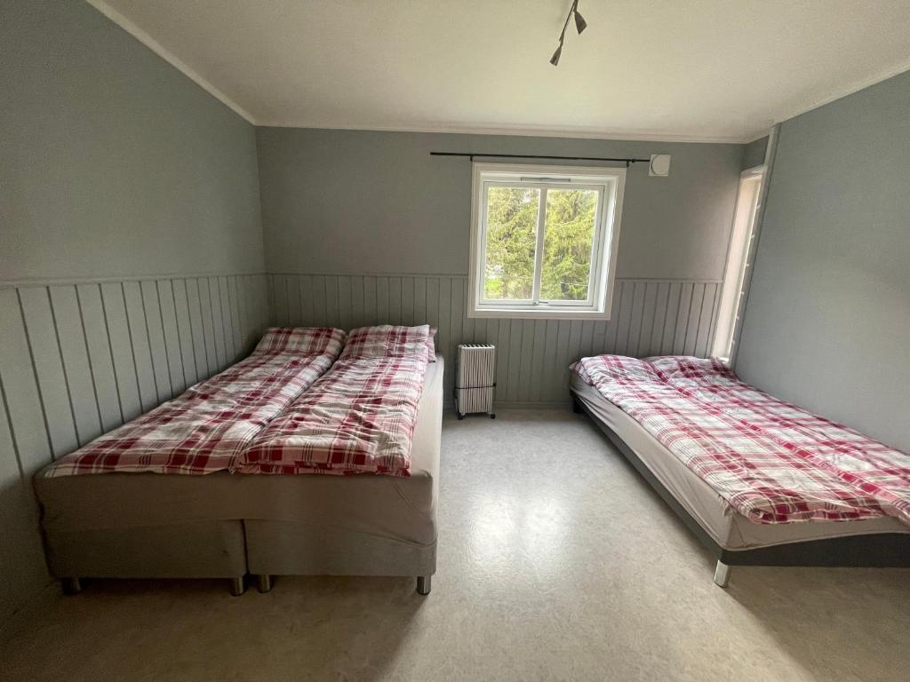 una camera da letto con due letti e una finestra di Aurora Tromsø Apartment a Tromsø