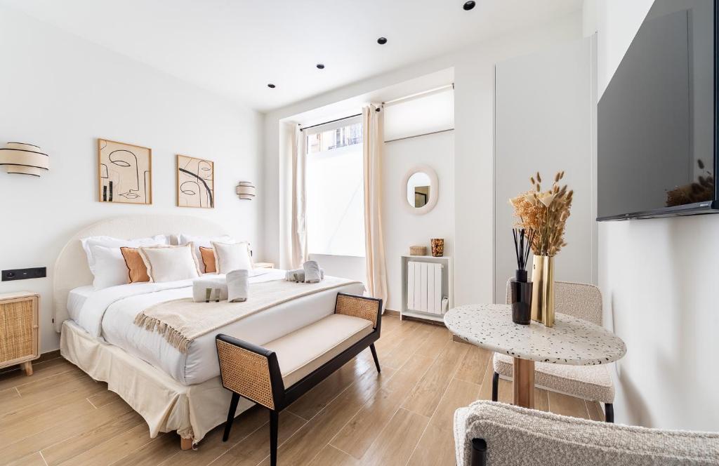 une chambre blanche avec un lit et une table dans l'établissement CIA - Eiffel tower, à Paris