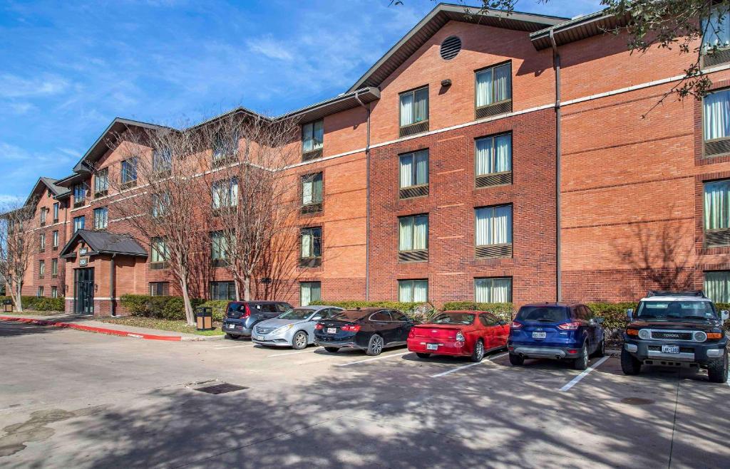 a large brick building with cars parked in a parking lot at Extended Stay America Suites - Houston - Westchase - Westheimer in Houston