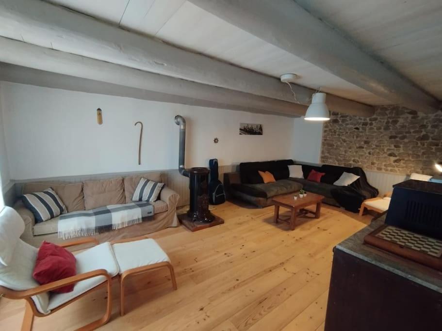 un salon avec un canapé et une table dans l'établissement Maison de campagne, cottage, à Saint-Genès-la-Tourette