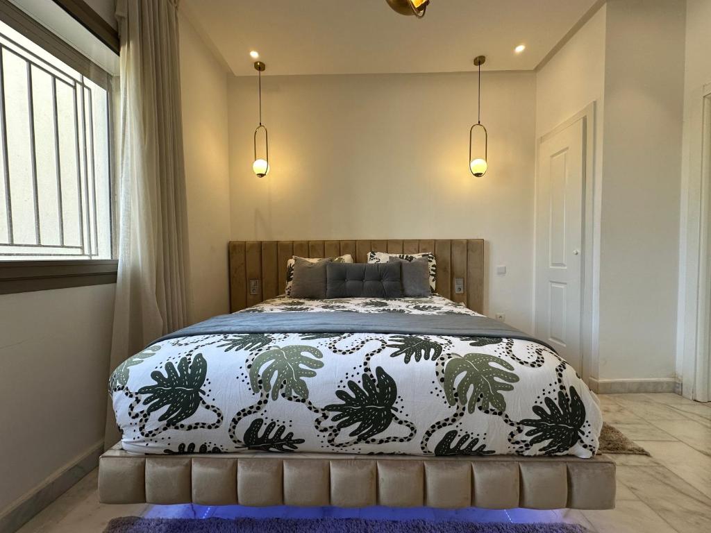 una camera da letto con un letto con un piumone bianco e nero di Airport Apartment Suite Casablanca FREE WIFI Modern Confort Calme a Derroua