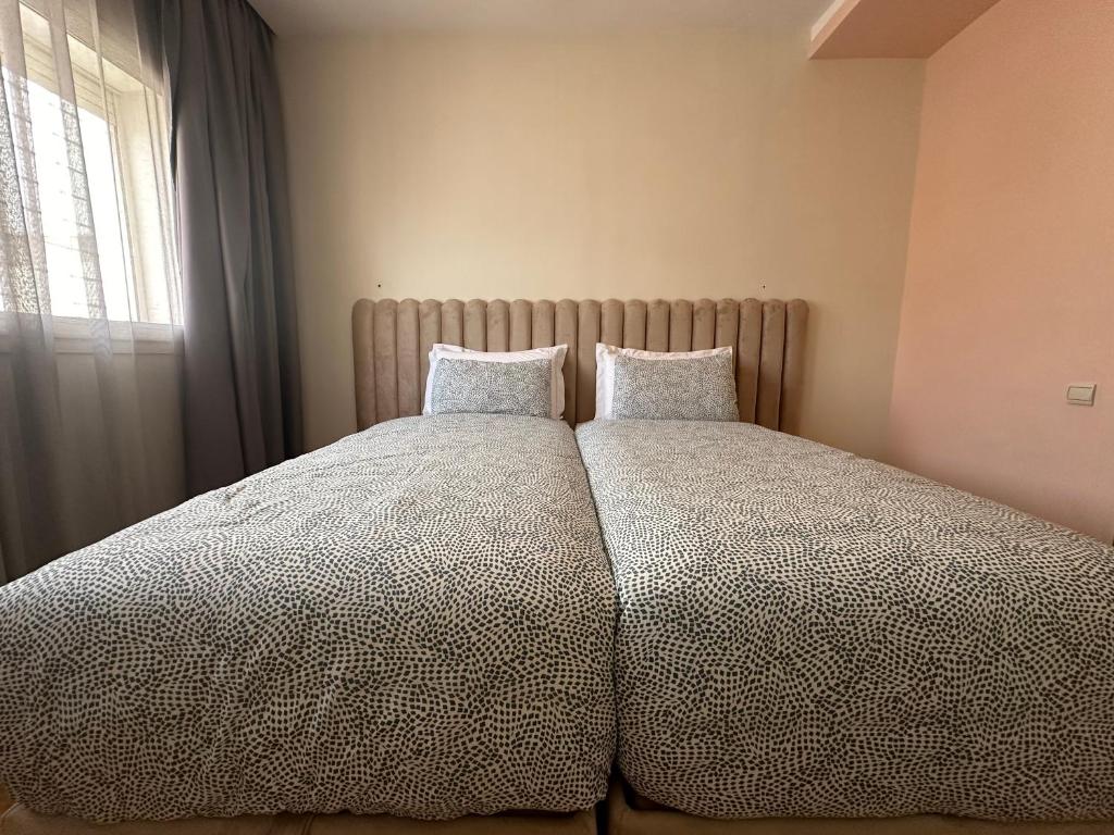 a bedroom with a large bed with two pillows at AeroChic in Nouaceur