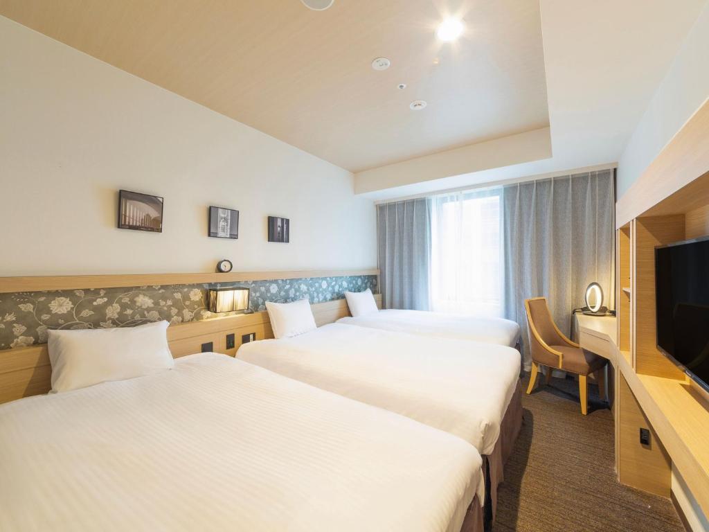 Postel nebo postele na pokoji v ubytování Hotel Keihan Yodoyabashi