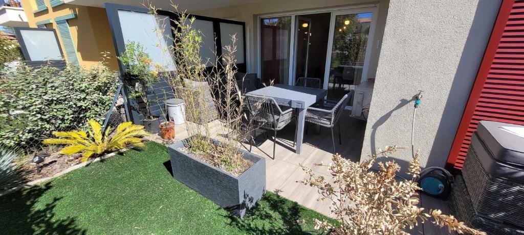 une terrasse avec une table et des chaises dans une maison dans l'établissement Cozy apartment with garden in Cogolin, à Cogolin