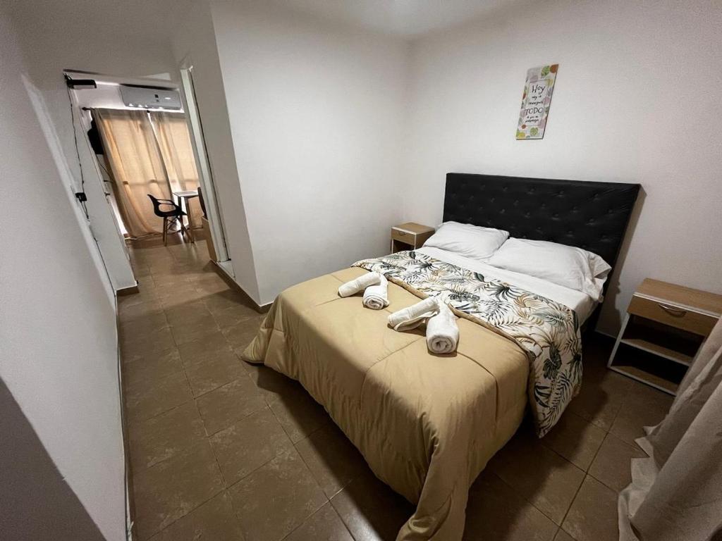 ein Schlafzimmer mit einem Bett mit zwei Handtüchern darauf in der Unterkunft hospedaje LH E a 15 minutos del aeropuerto ezeiza in Ezeiza