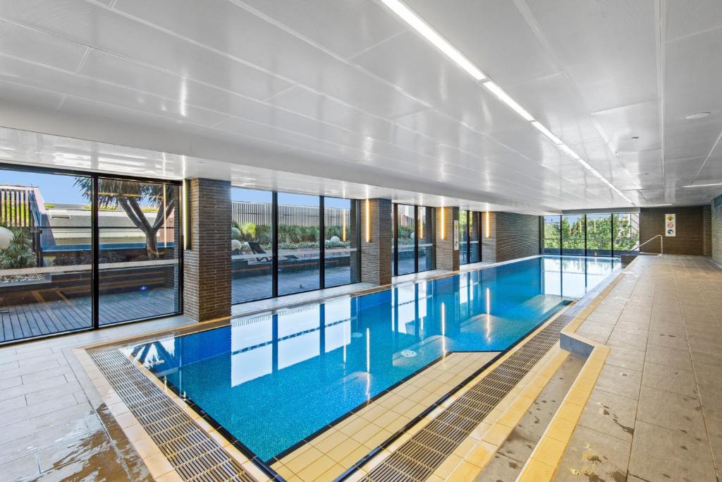 een groot zwembad in een gebouw bij Chic 1-Bed with Balcony Views and Amenities in Melbourne