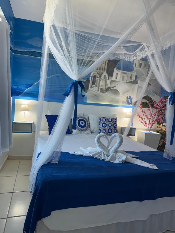 a bedroom with a blue bed with a white canopy at Flats Bela Vista Grécia in Macaé