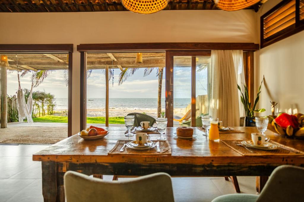 a dining room with a table with a view of the ocean at Casa ADOBE Preá - FRENTE MAR! in Prea