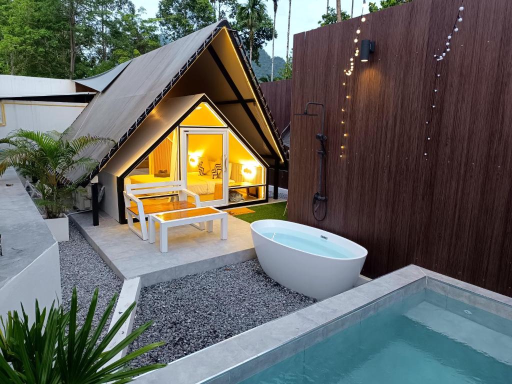 uma casa de banho com uma banheira ao lado de uma casa com uma banheira em Anita Camp stay em Parque Nacional de Khao Sok