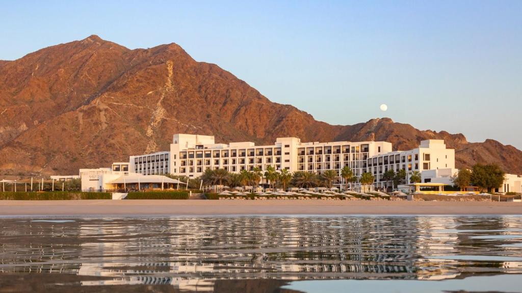 a hotel with a mountain in the background at InterContinental Fujairah Resort, an IHG Hotel in Al Aqah