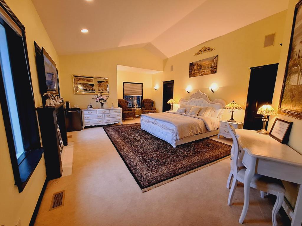 een grote slaapkamer met een bed, een bureau en een bureau bij Summer Express Kelowna B&B - Villa Bellissimo Fran-Talia in Kelowna