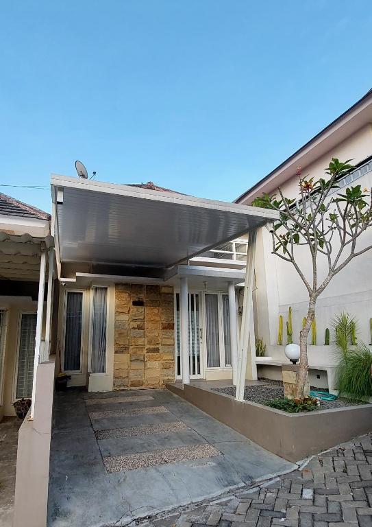 ein Haus mit einer schwarzen Markise in der Unterkunft Noosa Villa - Kota Batu in Batu