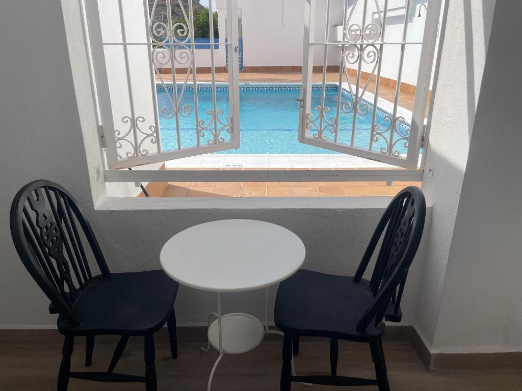 a table and two chairs and a table and a pool at Piso Luna in Mojácar