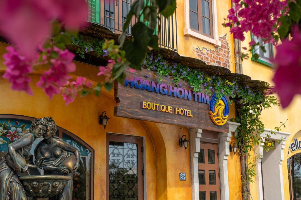 a sign on the side of a building with flowers at Hoàng Hôn Tím Boutique Hotel in Phú Quốc