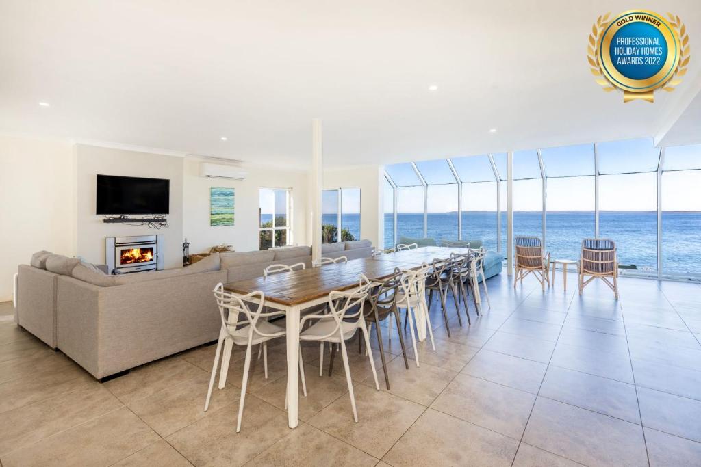 - une salle à manger avec une table et un canapé dans l'établissement Neptune I Absolute Beachfront I Stunning Views, à Culburra Beach