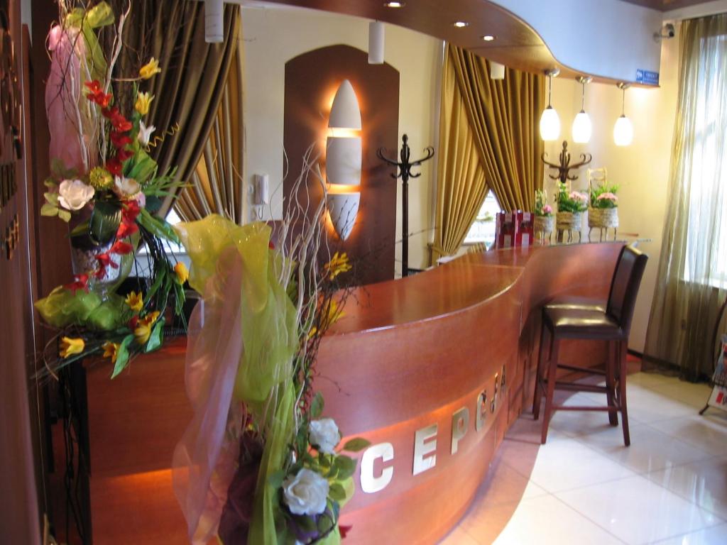 a bar in a hotel lobby with flowers on the counter at Hotel Korona in Ciechanów