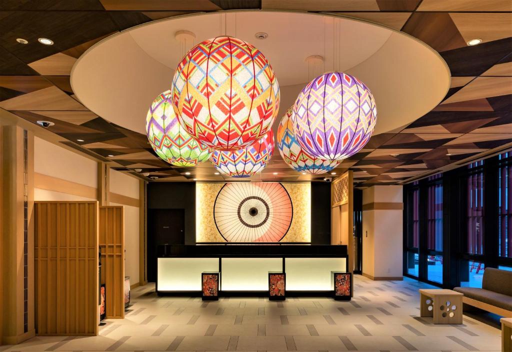 Daiwa Roynet Hotel KANAZAWA-MIYABI في كانازاوا: لوبى مع أضواء ملونة معلقة من السقف