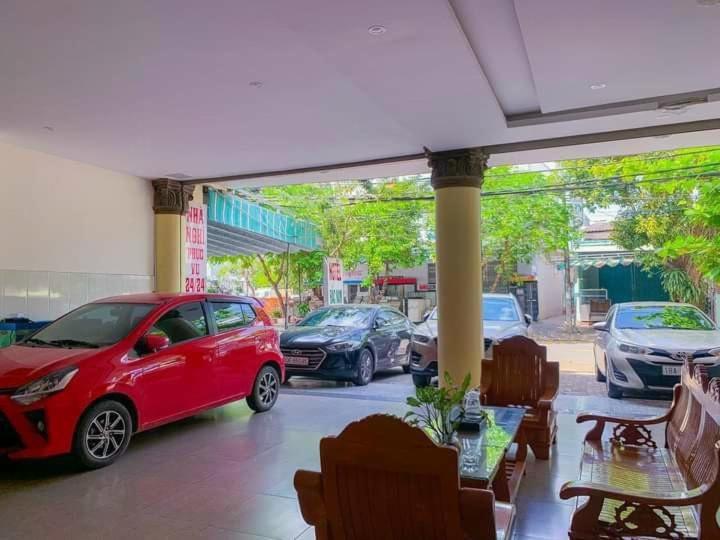 un coche rojo estacionado en un estacionamiento con coches estacionados en Bắc Nam Hotel DN by - BAY LUXURY, en Da Nang
