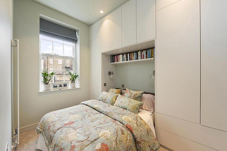 een slaapkamer met een bed en een raam bij Elegant London Townhouse in Londen