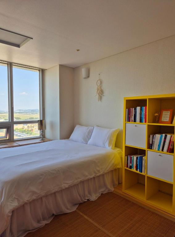 sypialnia z dużym łóżkiem i półką na książki w obiekcie Cozy Bright Studio w mieście Inczon
