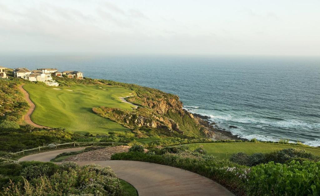 a golf course on a cliff next to the ocean at La Best Pinnacle Point Lodges & Villa in Mossel Bay